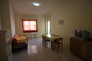 新福卡Appartamenti San Foca的客厅配有桌子和电视