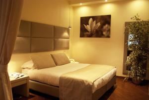 卡萨诺德莱穆尔杰Il Portico Luxury B&B的卧室配有一张床,墙上挂有绘画作品