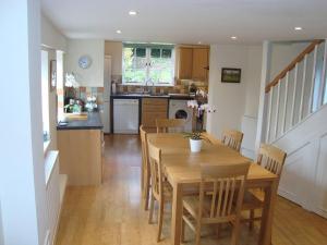 PewseyStunning 3 bedroom 3 bath self catering cottage near Stonehenge Avebury and Bath Great village pub的厨房以及带木桌和椅子的用餐室。