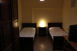 斯拉沃尼亚布罗德Prenoćište "Magnus"的一间卧室设有两张床和一张桌子上的台灯。