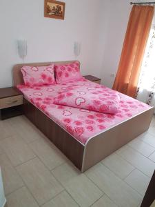 阿拉德Onalisa的床上配有粉红色床单和粉红色枕头