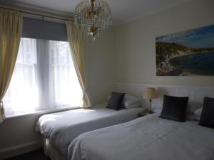 伯恩茅斯Southernhay Guest House的卧室内的两张床,配有吊灯和窗户
