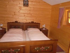东蒂罗尔地区马特赖Riepleralm的小木屋内一间卧室,配有一张床
