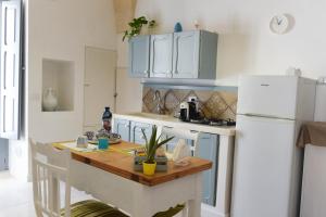 佩兹迪格雷科Casa Mida - Guest House的厨房配有桌子和白色冰箱。