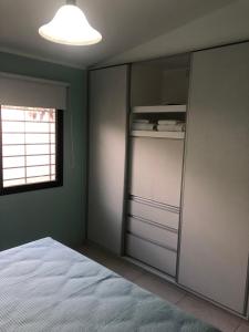 圣拉斐尔Santa Rita的一间卧室配有一张床和一个玻璃衣柜