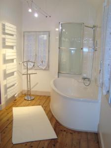莱萨布勒-多洛讷Maison l'épicurienne的白色的浴室设有浴缸和淋浴。