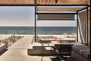 库鲁塔Dexamenes Seaside Hotel的一个带桌椅的庭院和大海