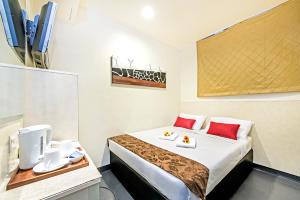 新加坡Hotel 81 Selegie的配有红色枕头的床的酒店客房