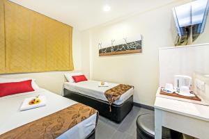 新加坡Hotel 81 Selegie的酒店客房设有两张床和一张桌子。