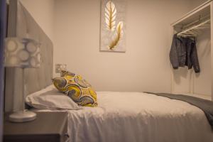 马拉加Apartamento Padilla Playa Huelin的一间卧室配有一张带枕头的床