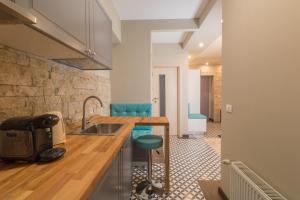 锡纳亚Romantic Jacuzzi Belleview Studio的厨房配有水槽和带蓝色凳子的台面