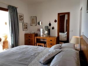 莫哈卡尔Villa Sellares的一间卧室配有一张床、一张书桌和一面镜子