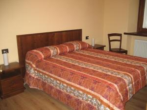 瓦尔佩利内Deliziosa casetta的一间卧室配有一张大床和木制床头板
