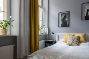 波兹南Apartament Jana Matejki的一间卧室设有床和黄色窗帘的窗户