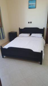 西迪伊夫尼HOTEL BEACH CLUB LEGZIRA的卧室内的一张带白色床单和枕头的大床