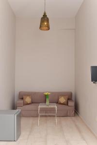 埃尔莫波利斯Oisyra Hotel的客厅配有沙发和桌子