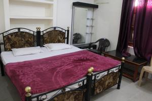 奥拉奇哈Best B&B in Orchha的一间卧室配有一张大床和紫色毯子