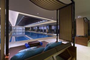太原太原富力万达文华酒店的酒店设有一个大型游泳池,配有蓝色家具