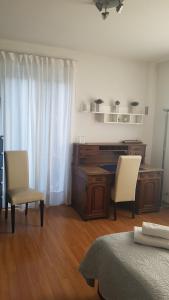卢加诺Homestay Dodo的一间卧室配有书桌、两把椅子和一张床