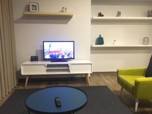 拉梅戈Apartamento da Seara "Douro"的一间客厅,在白色的橱柜上配有电视