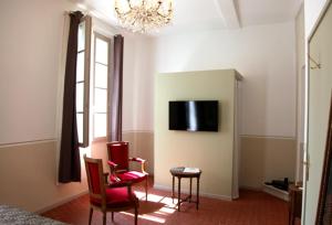 拉西约塔拉梅森德奥黛特住宿加早餐旅馆的卧室配有两把椅子和墙上的电视。