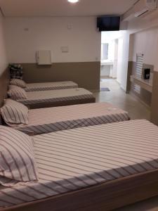 圣保罗YES情趣酒店（仅限成人）的三个床在一间房间里排成一排