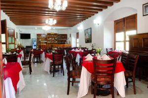 San Pedro y San Pablo TeposcolulaHotel Casa Franco的餐厅设有红色和白色的桌椅