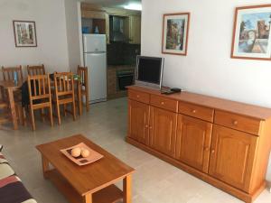 安波拉Precioso apartamento cerca de la playa的客厅配有电视和一张带鸡蛋托盘的桌子