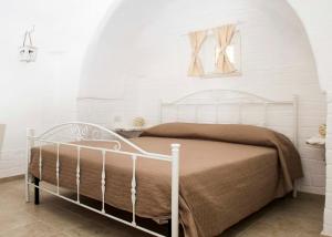 马丁纳弗兰卡Trulli Centenari的卧室内的白色床,设有白色的墙壁
