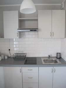 斯图托沃Apartament Mierzeja的厨房配有白色橱柜和水槽