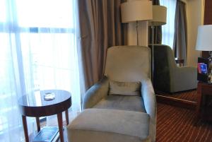 顺义北京临空皇冠假日酒店的客厅配有椅子和桌子