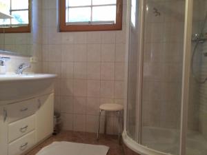 锡利安斯科斯尔霍夫酒店的带淋浴、盥洗盆和凳子的浴室