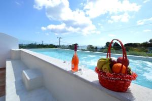 法里拉基卡塔拉湾公寓酒店的坐在游泳池旁的树 ⁇ 上,一篮水果