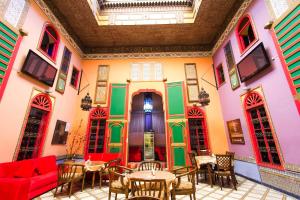 非斯Riad Haj Palace & Spa的色彩缤纷的墙壁、桌子和椅子