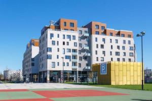 俄斯特拉发Golden Apartments Rezidence Nová Karolina的城市两座高大的白色建筑,有停车位