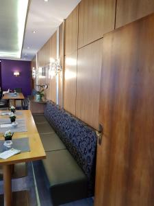 梅灵Hotel "Zum Moseltal"的餐厅设有木墙、桌子和门