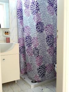 锡蒂亚Sitia Holidays 1的浴室设有紫色和白色的淋浴帘