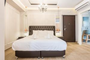 雅典Syntagma Luxury Living One “LL1” Apartments的卧室配有一张带吊灯的大型白色床。