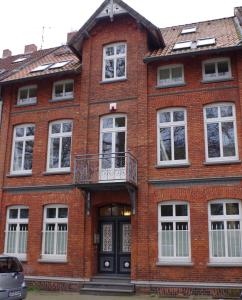 吕讷堡Villa Friedenstraße 11的红砖建筑,设有阳台和门