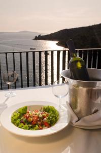 赫瓦尔Hotel Sirena Hvar的桌上一盘沙拉和一瓶葡萄酒