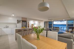努萨维尔Anchorage - Riverfront Luxury on Gympie Terrace的厨房以及带桌椅的起居室。