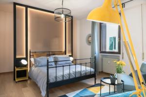 佛罗伦萨B&B La Marmora 39的一间卧室配有黑色的床和黄色的灯