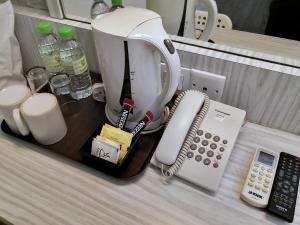 吉隆坡Hotel Westree KL Sentral的咖啡壶和柜台上的电话