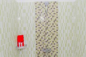 井里汶RedDoorz Plus @ Tuparev Cirebon 2的墙上装有红色物品的淋浴浴室
