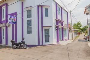 井里汶RedDoorz Plus @ Tuparev Cirebon 2的停在紫色和白色建筑前的摩托车