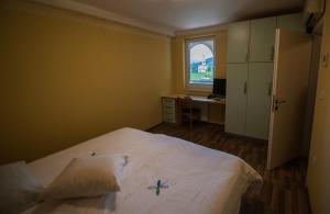 KodretiHiša posebne Sorte的一间卧室配有一张床、一张书桌和一个窗户。
