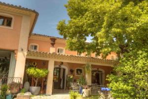 穆斯捷-圣玛丽菲尔莫玫瑰迷人酒店的一座大桃色房子前面有树木