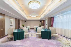 深圳深圳东方银座酒店 的一间设有桌椅和天花板的会议室