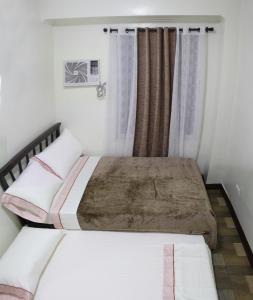 科隆Dignadice's Homestay的一间卧室设有两张床和窗户。