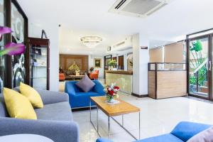 曼谷Lasalle Suites Hotel & Residence的客厅配有蓝色的沙发和桌子